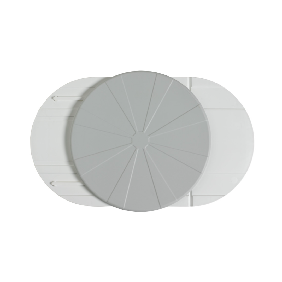 A top-down view of the Vitaturn Swivel and Transfer Aid, a light gray, circular device with segmented lines, positioned overlapping two elongated white oval components on a plain white background.
